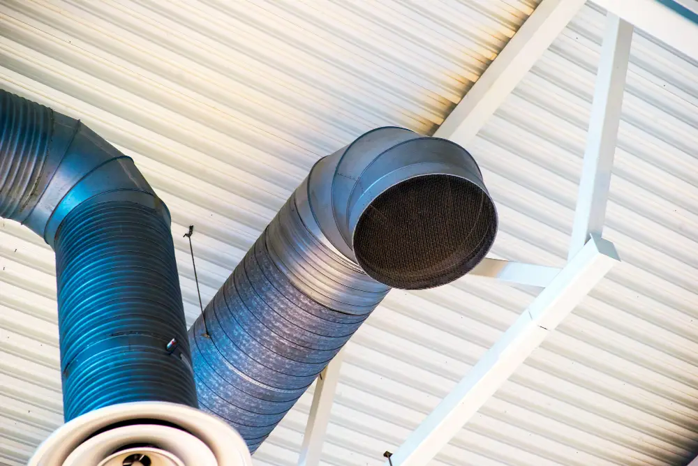 Ductwork system with metal ventilation pipes and grill, illustrating air duct cleaning services for improved indoor air quality in Hampton, NH.