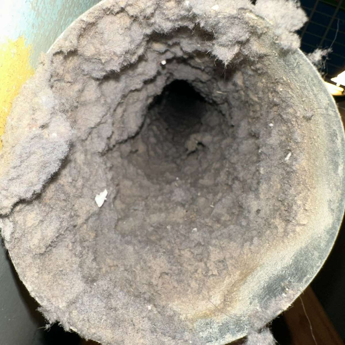 Accumulated lint and debris inside a dryer vent, illustrating fire hazard risks associated with uncleaned vents.