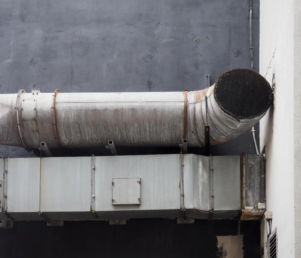 Deteriorating ductwork and vent system on a building exterior, emphasizing the need for professional air duct and dryer vent cleaning services in Portsmouth, NH.