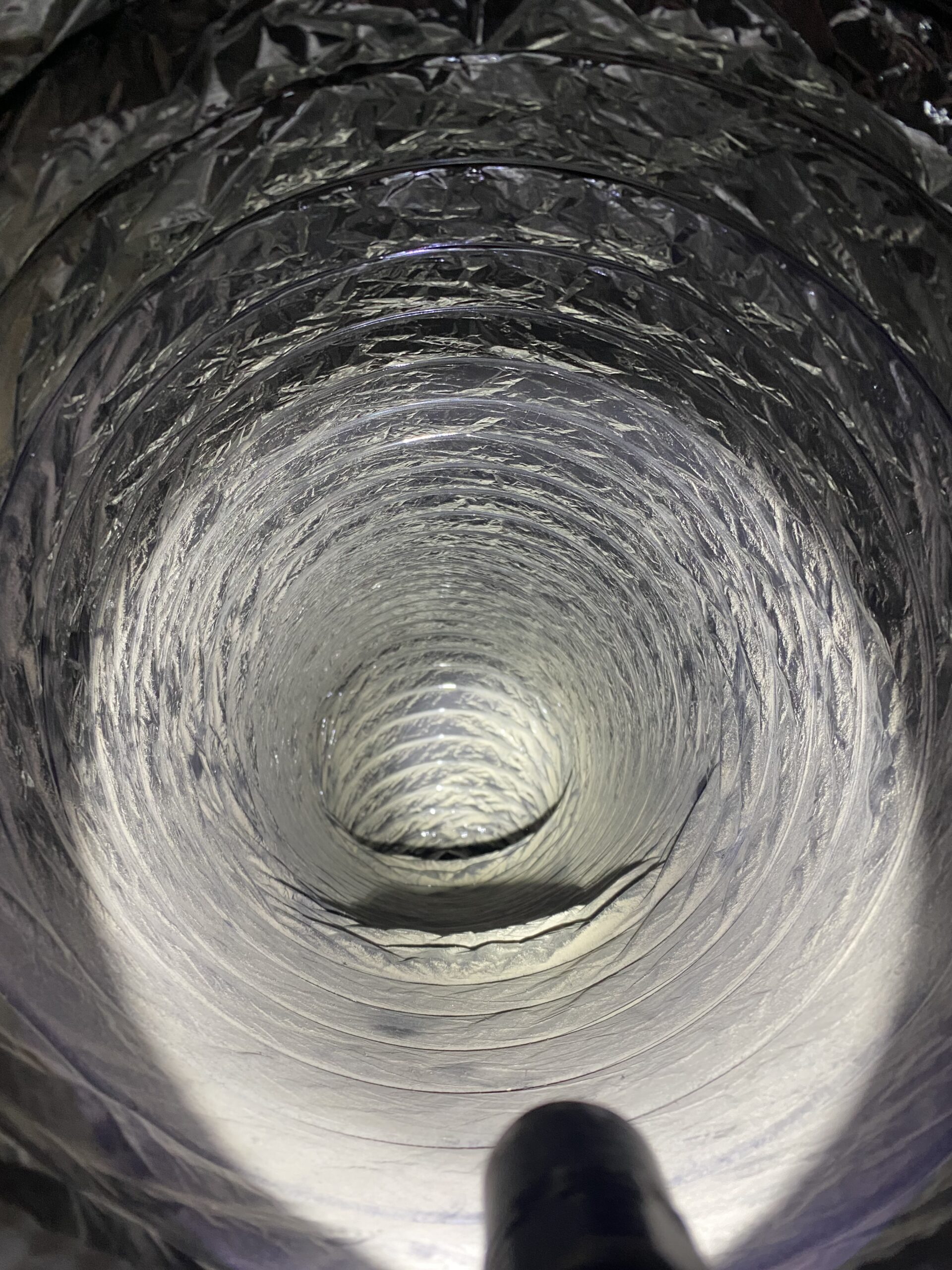 Interior view of a clean dryer vent duct, showcasing smooth airflow pathway free of lint buildup, emphasizing dryer efficiency and fire safety.
