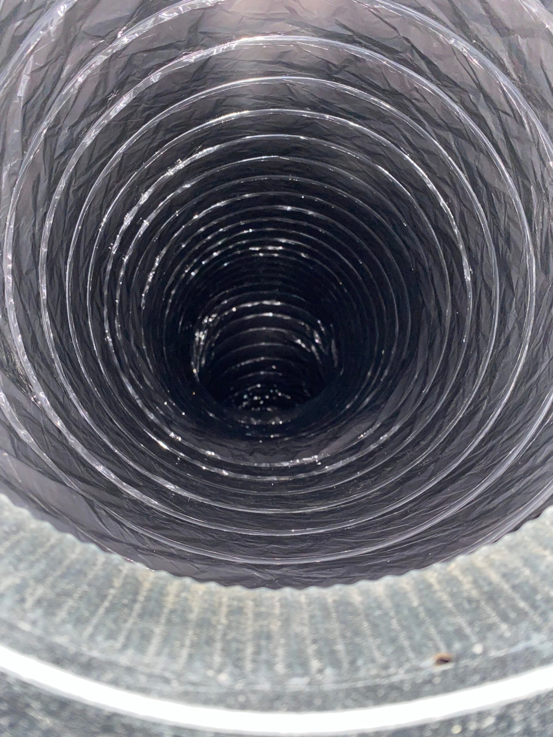 Dryer vent duct showing lint buildup and restricted airflow, highlighting the importance of regular cleaning for safety and efficiency.