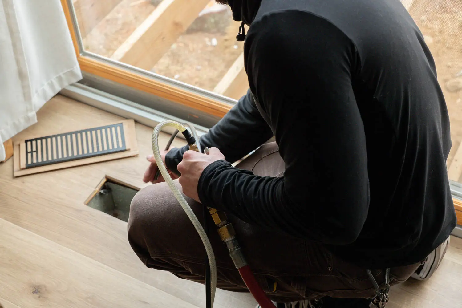 Professional technician using equipment for air duct cleaning in a Salisbury home, focusing on maintenance and efficiency of HVAC systems.
