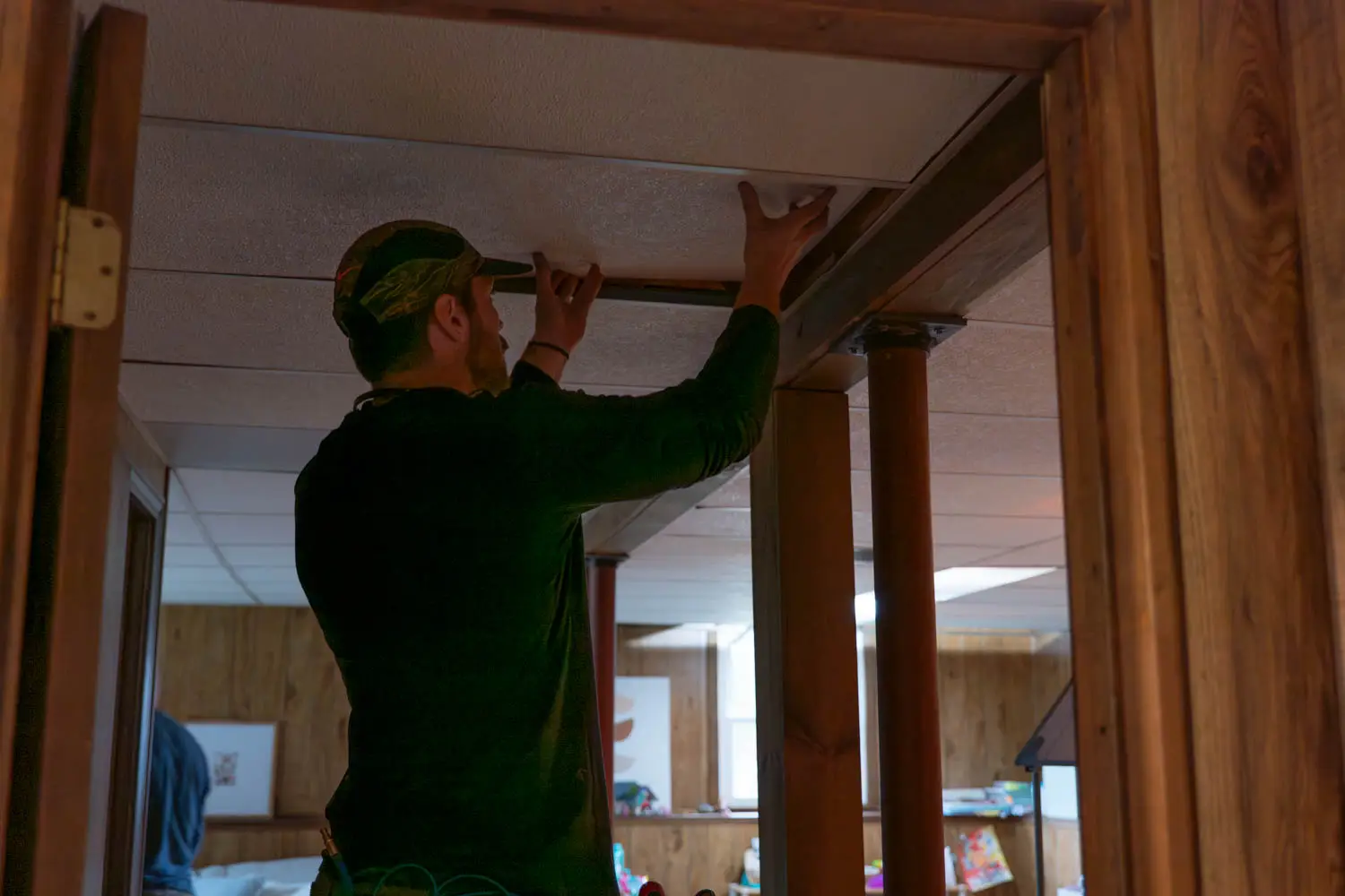 Technician cleaning air ductwork in basement, removing damp organic dust and pollen.