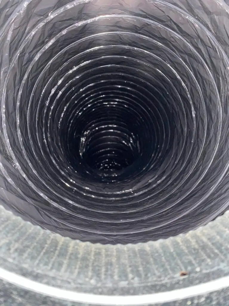 Close-up view of a black dryer vent duct showing spiraled interior, illustrating Kealey's Duct and Dryer Cleaning Service's focus on thorough inspection and lint removal.