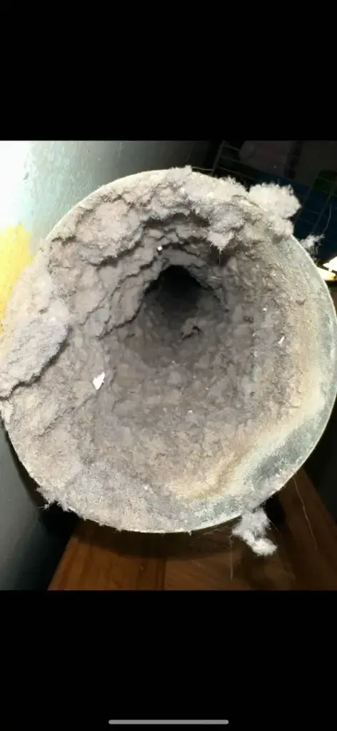 Lint-filled dryer vent duct highlighting the importance of regular cleaning for fire safety and efficiency, as discussed in the context of dryer vent maintenance.